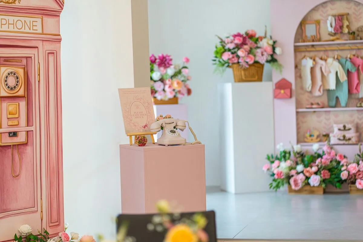 Baby shower planner London — pink setup with flowers and baby clothes by Eshas Events